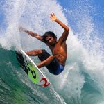 Atlet Selancar Yang Berdiri Di Atas Papan Agar Seimbang